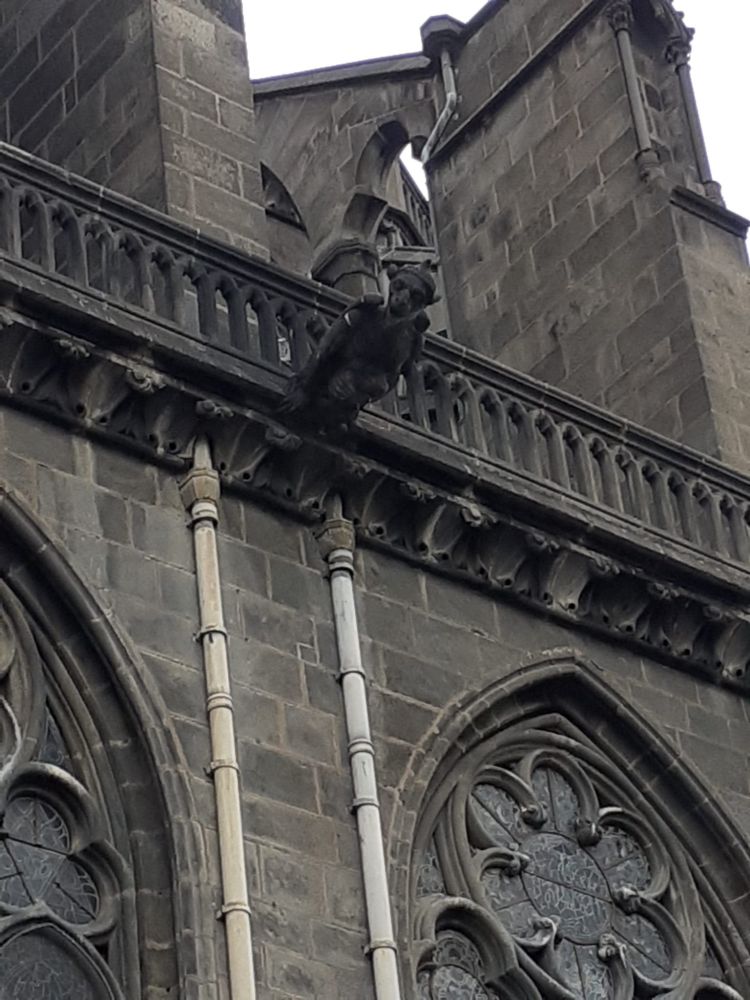 Une gargouille à tête de singe qui dépasse du toit de la cathédrale et semble regarder en direction de l'objectif. 