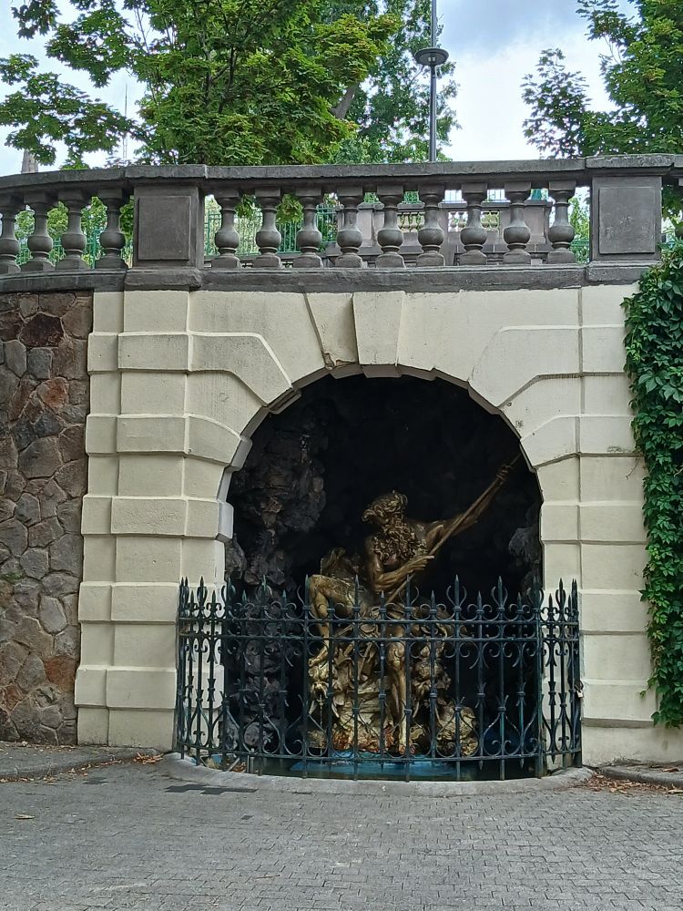 Statue de Poséïdon derrière des barreaux vue dans un square.