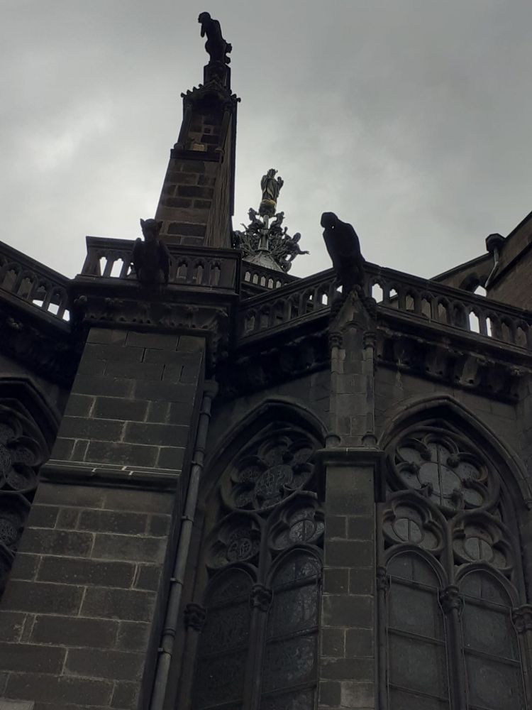 Une partie du toit de la cathédrale de pierres noires où on aperçoit une statue de la Vierge.