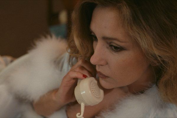 Caroline Cellier (Anna Foscarie) au téléphone en nuisette sur son lit.