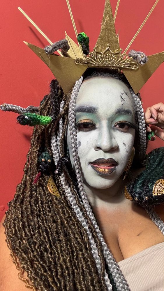 A black wom dressed as Medusa for Halloween. The snakes are make of braiding hair 