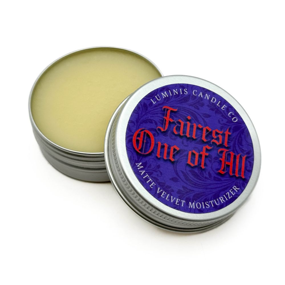 A silver tin containing a pale yellow balm. The label on the lid reads "Fairest One of All".