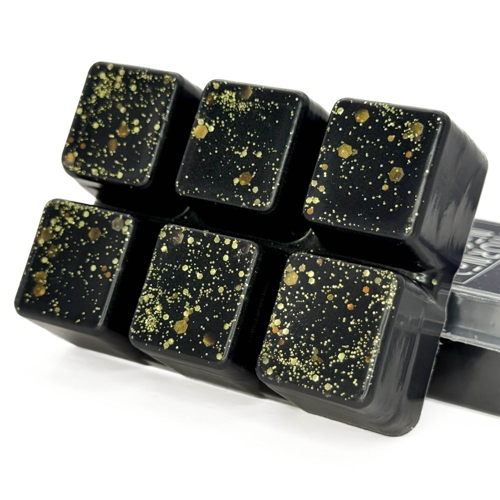 Black wax melts in a set of 3x2 connected cubes, decorated with various sizes of gold glitter.