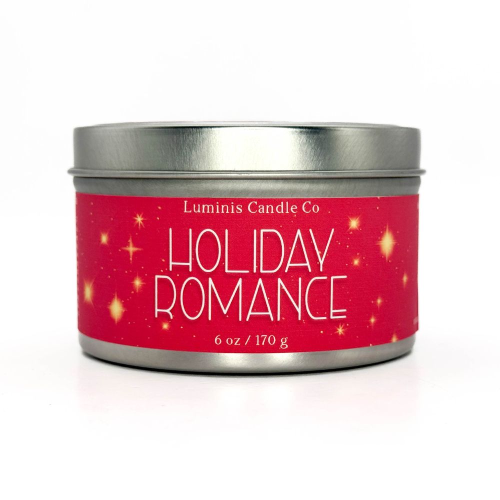 A silver candle tin with a label that reads "Holiday Romance".