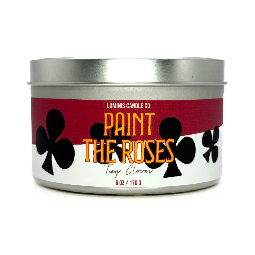 A silver candle tin with a label that says the scent name, Paint the Roses.