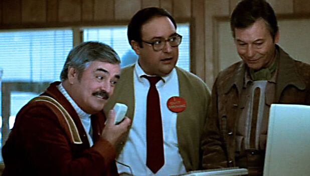 Montgomery Scott, clearly acclimating to 80’s tech, by speaking into a computer mouse. “Hello computer” he says. Dr McCoy and man from the 80’s look on.