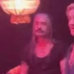 blurry fuzzy screenshot of edward teach looking apathetic while everyone else is enjoying life 