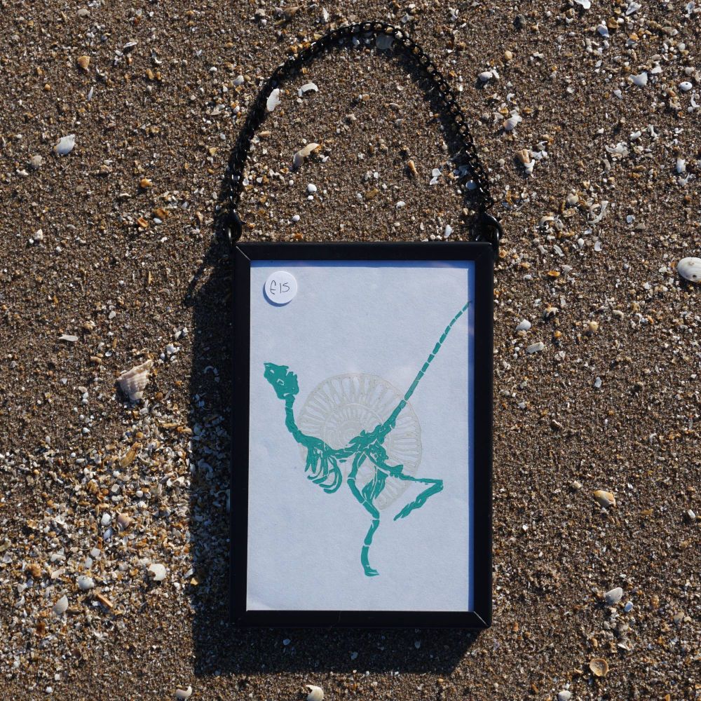 A frame on sand with artwork of a fossil