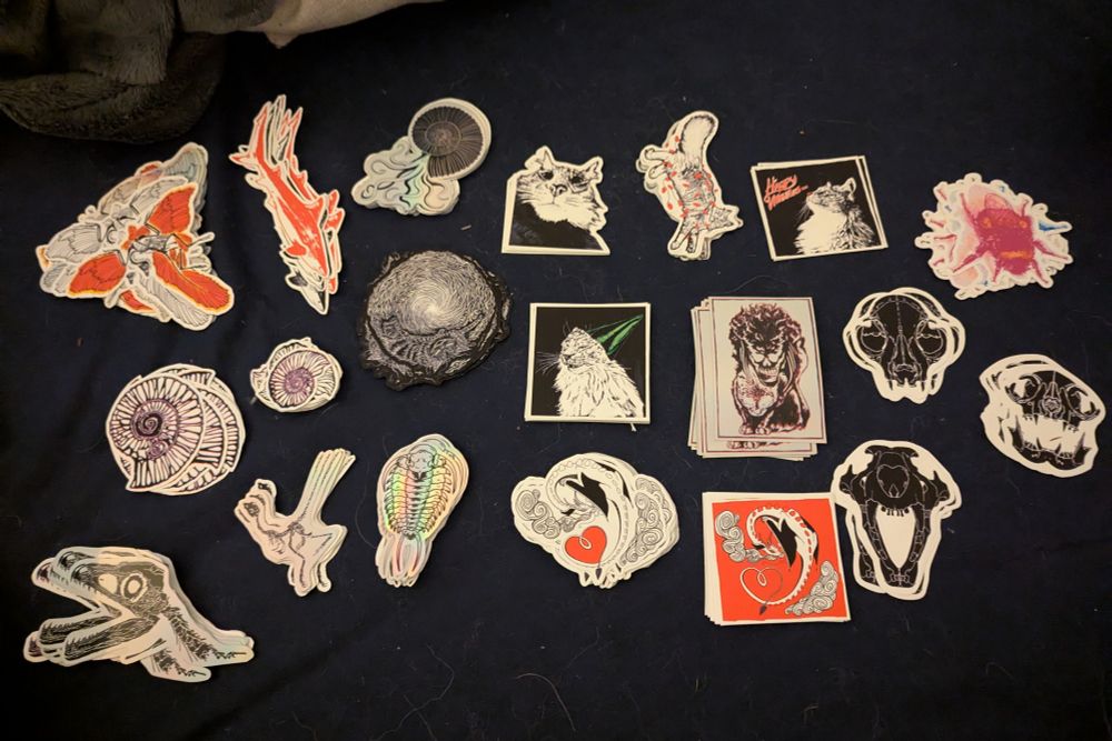 Stickers laid out on a bed of varying designs, organized by artwork