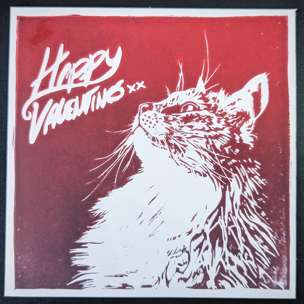 A red gradient lino printed image of a cat looking upwards to the left top corner where it reads "happy Valentines xx"