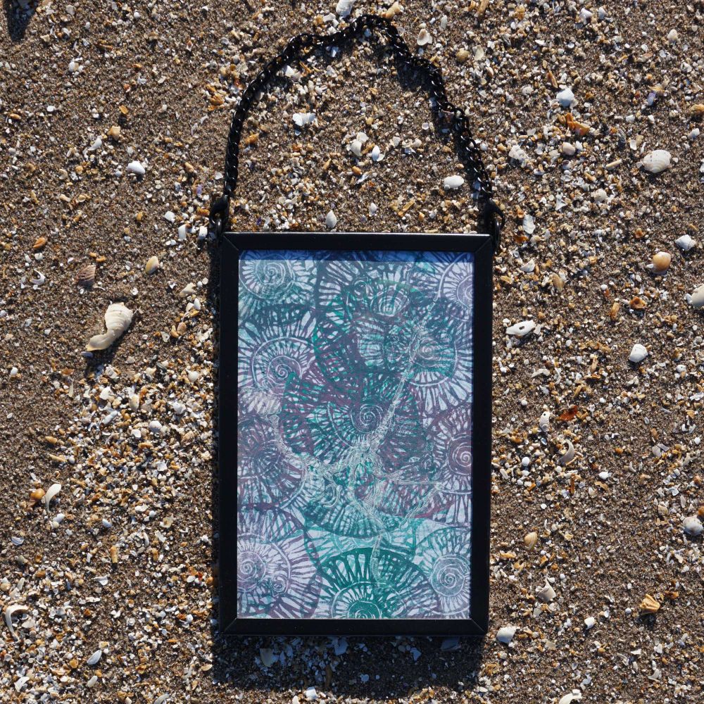 Frame on sand with artwork of Ammonites 