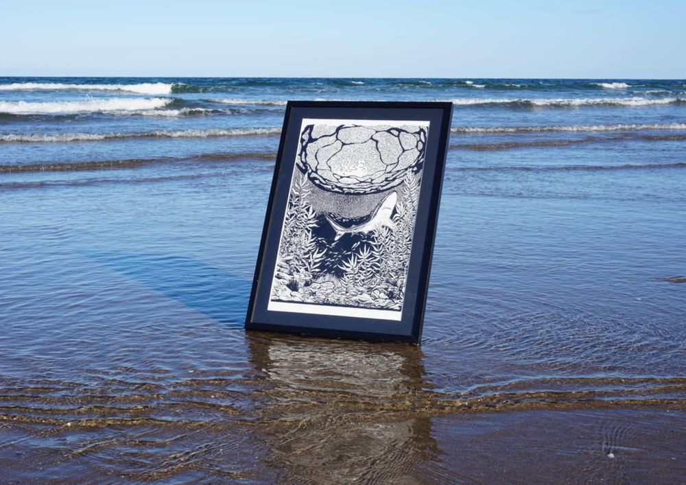 Photograph of my print 'ocean blue' taken at the beach. The print is surrounded by the incoming tide making it look as if it is floating on the water