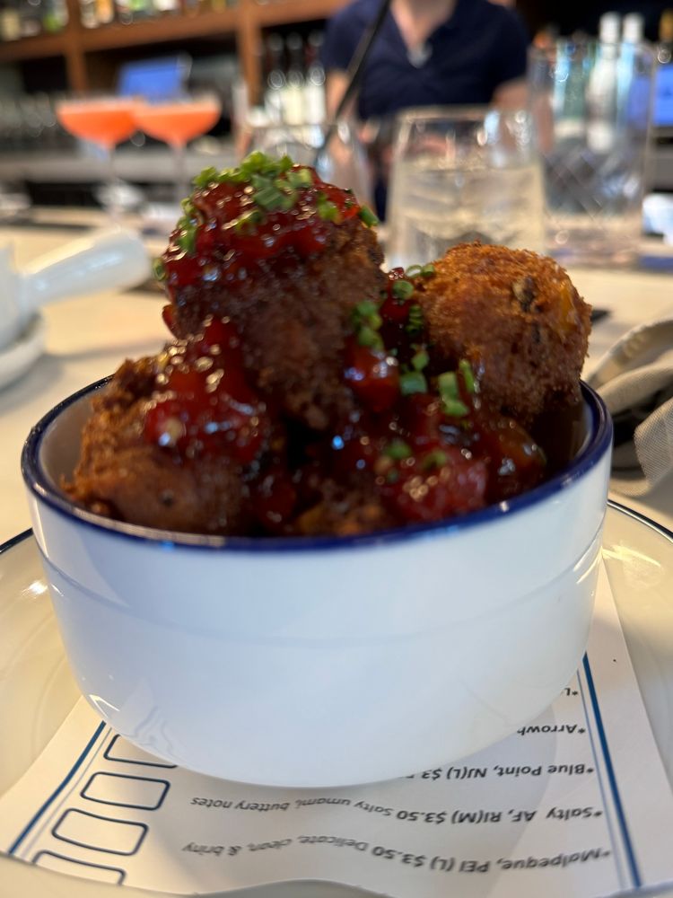 Hush puppies piled high and covered with chives and jelly.