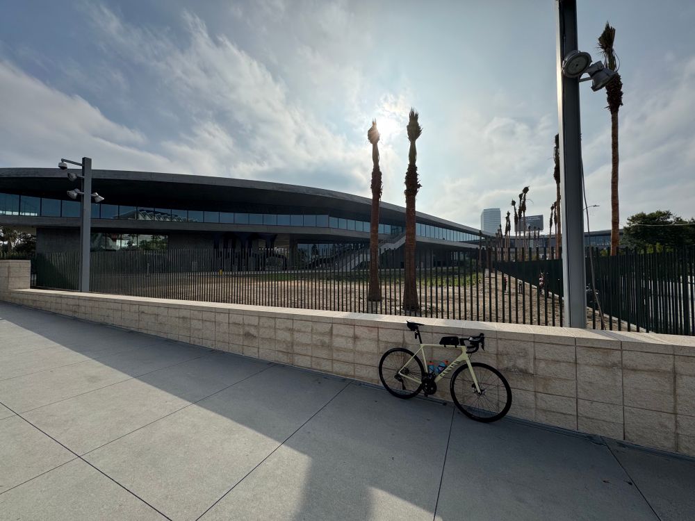 A yellow Canyon Endurace road bike leans against a low stone wall. Behind it is some kind of weird concrete and glass amoeba looking thing, which is allegedly the new Los Angeles County Museum of Art galleries, or will be, when it opens next year.