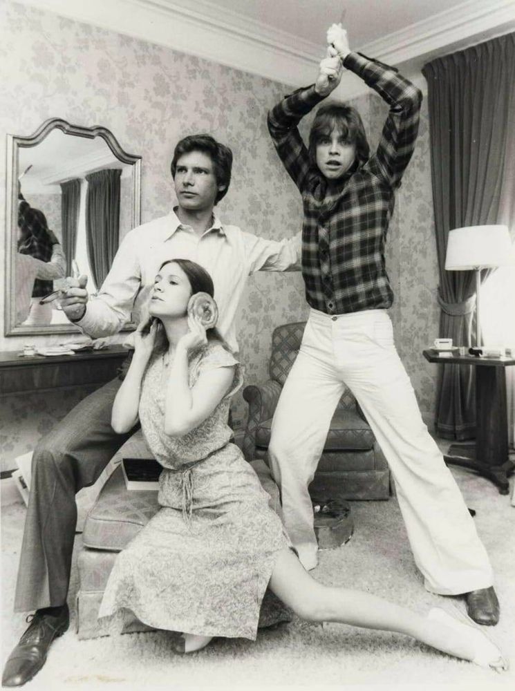 Harrison Ford, Carrie Fisher, and Mark Hamill recreating the Star Wars poster