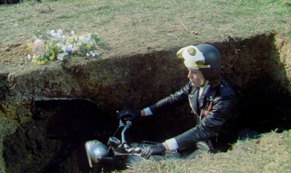 Person on a motorbike, both in an open grave
Psychomania (a.k.a. The Death Wheelers), Dir. Don Sharp, 1973.