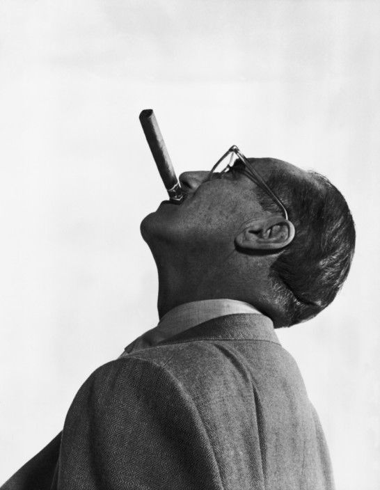 man, cigar in mouth, looking up