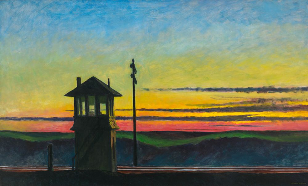 sigmal box next to a rail line. a rolling hill landscape with the sun setting behind.
