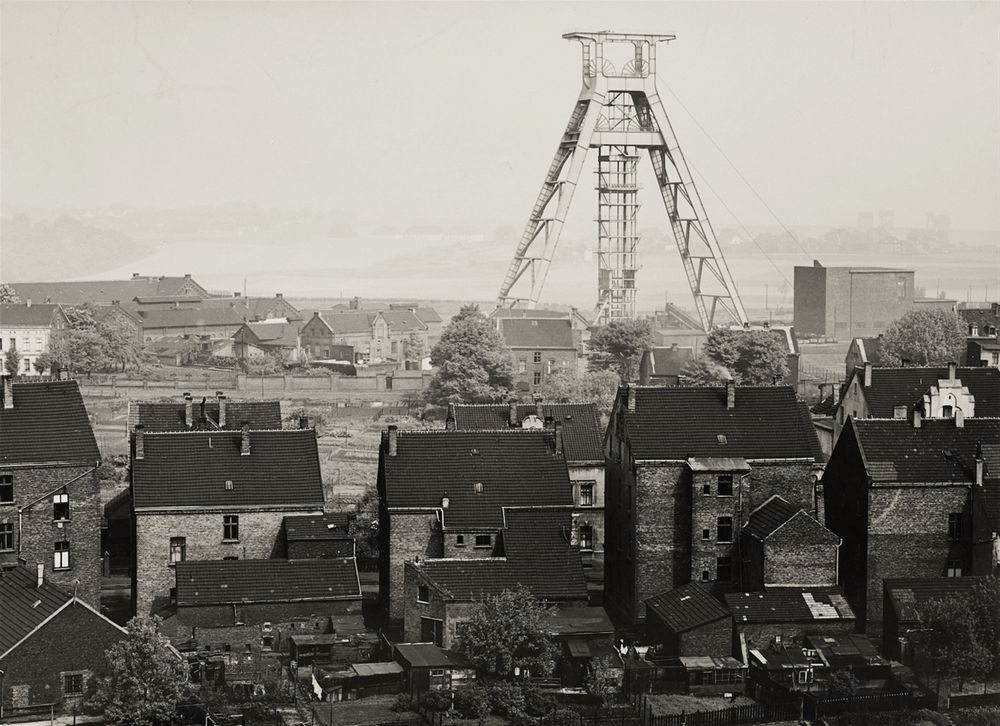 view over a town with a large mine crane dominating the scene