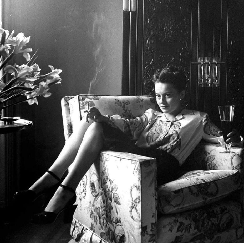 Big Liv sat across an armchair, smoking some Red Lebanese and swilling from a decanter of Ribena.