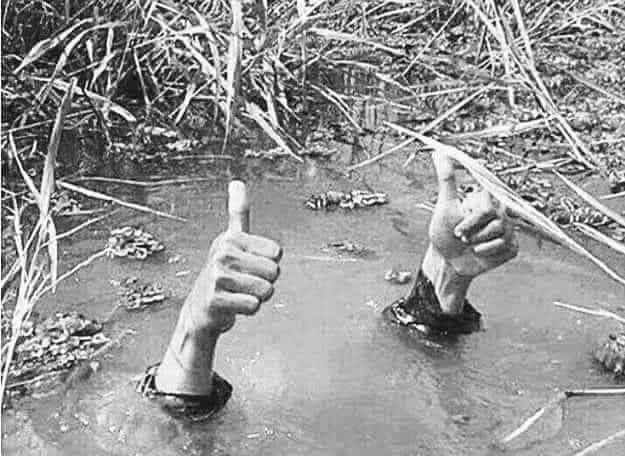 the hands in a deep pool of water, they are giving the thumbs up