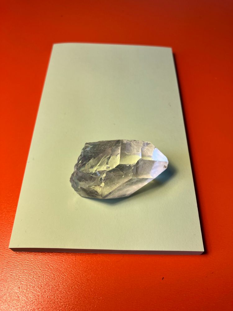 Clear crystal on a yellow post it note 