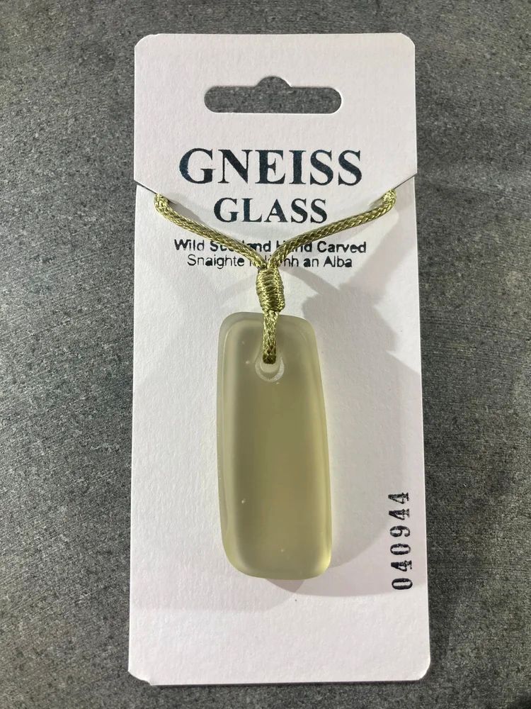 Green glass matt finish cold carved pendant on a white hand stamped mounting card featuring a serial number and Gneiss Glass branding 