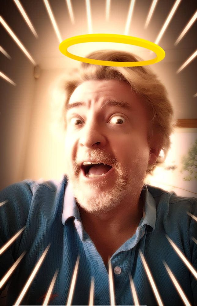 Picture of our holiest of holies, St Rhysie of Darby. He is smiling, surrounded by golden beams, emanating from his gorgeous face. A golden halo is seen hovering over his glorious hair.