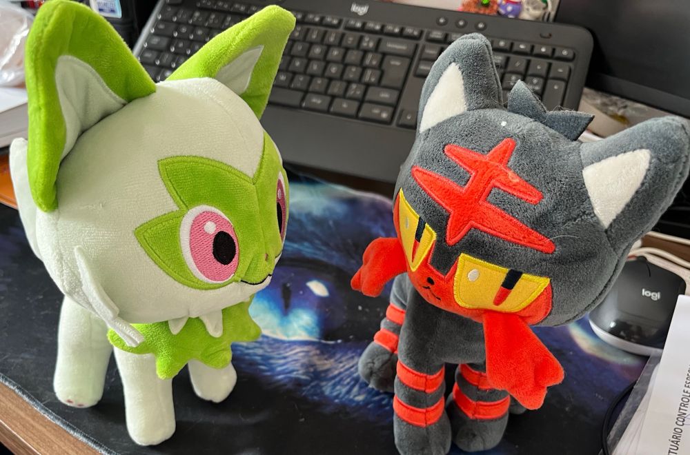 Sprigatito and Litten plushies in a desk 