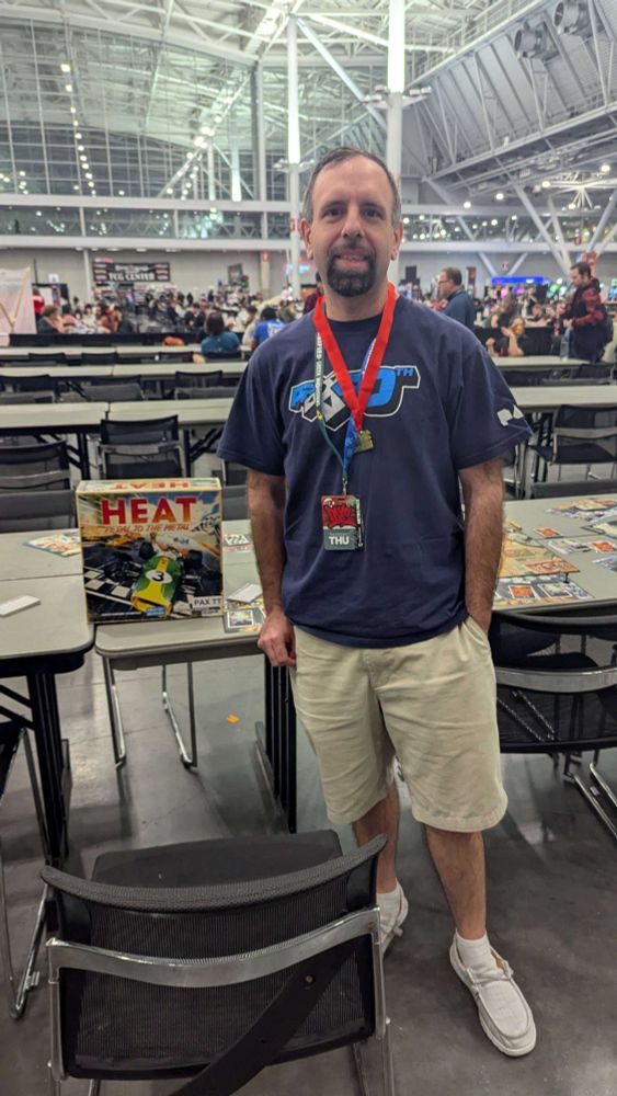 Attendee of PAX East 2025 posing with board game (Heat) and medal