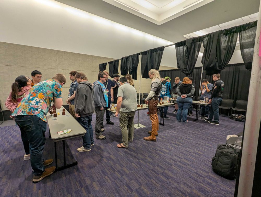 Players standing at a game, in a convention center meeting room
