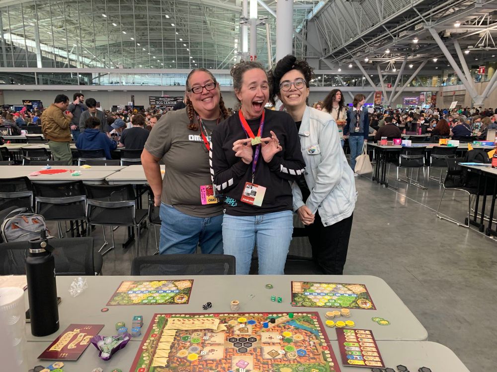 Winners of a Castles of Burgundy tournament at PAX East 2025, posing with medals 