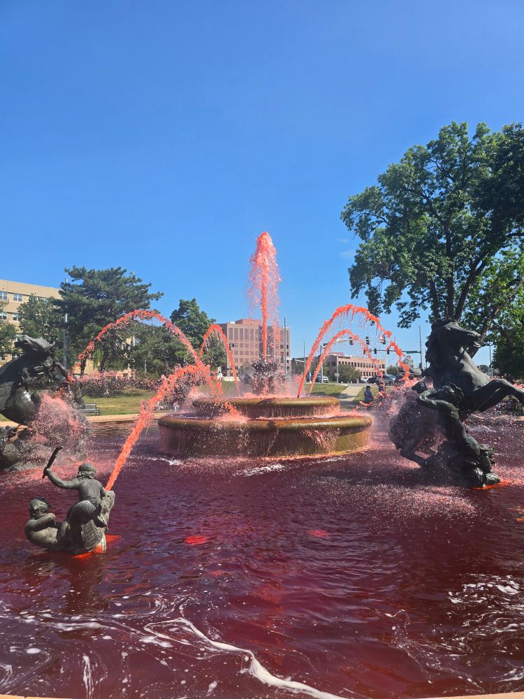 A fountain with multiple spouts shooting red dyed water