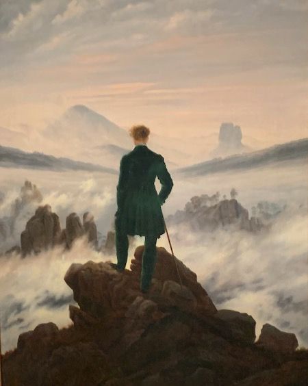 Der Wanderer von Caspar David Friedrich. Mann von hinten steht auf dunkler Klippe vor Nebelmeer und blickt in die Ferne. Fotografiert auf der CDF Ausstellung in Hamburg