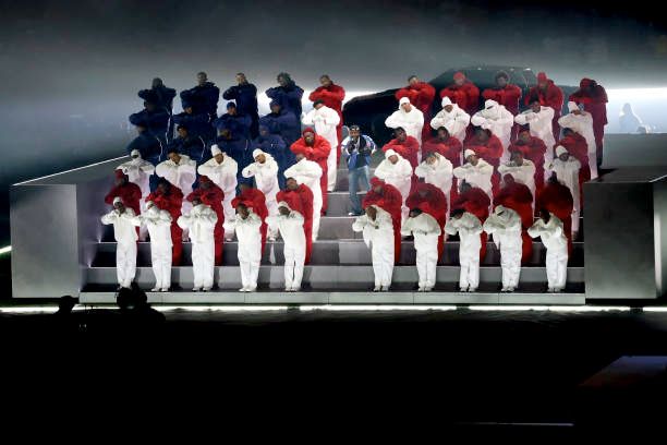 performers during kendrick lamar's half time show in position to look like an american flag with kendrick singing in the center 