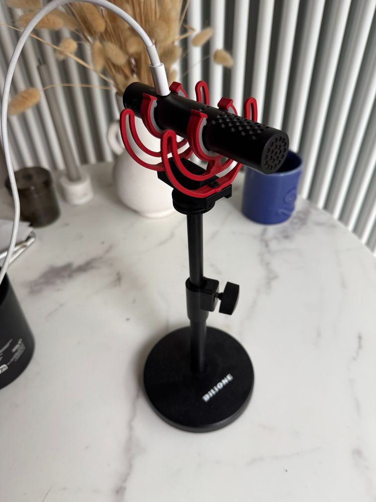 A rode videomic, on a camera mount, put on a stand precariously.