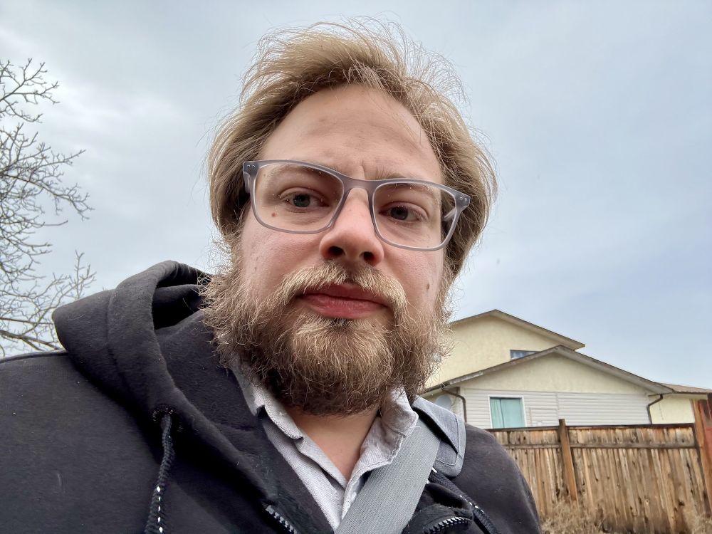 A photo of myself looking at the camera walking outside on a cloudy day