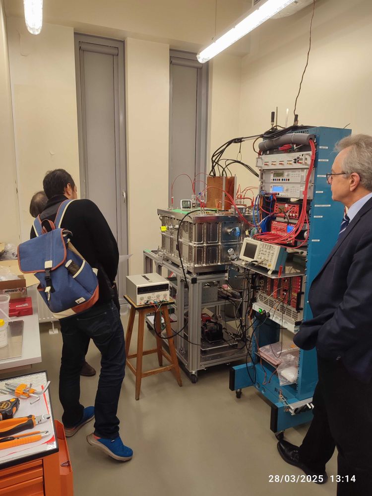 Visitors observing experimental physics equipment during a laboratory tour at the University of Warsaw.