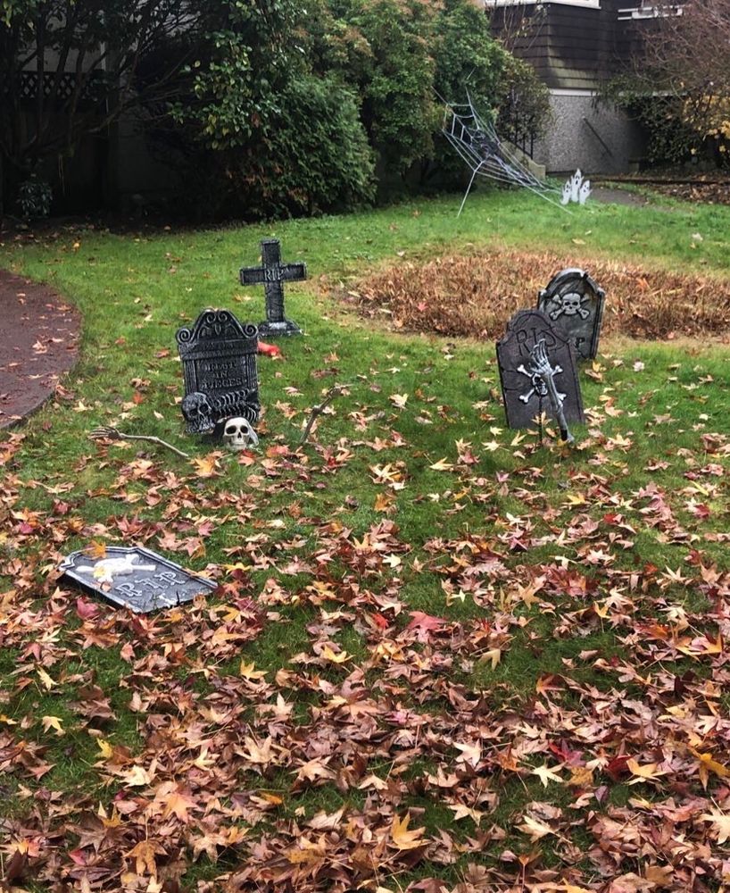 Uma decoração feita no jardim de uma casa para parecer um cemitério com lápides.