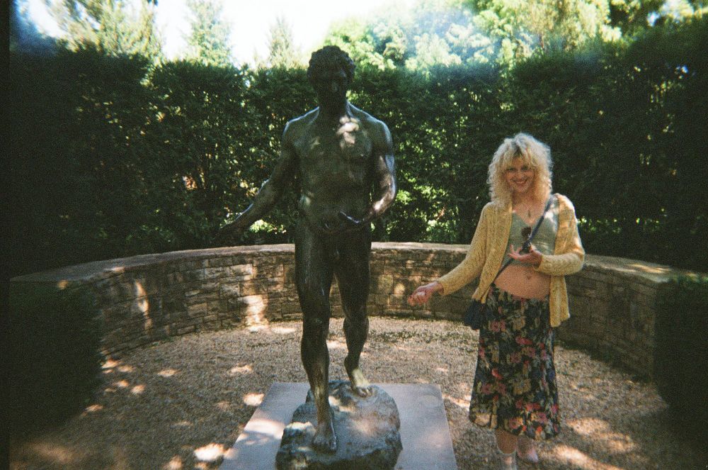 hattie standing next to a statue and imitating its pose