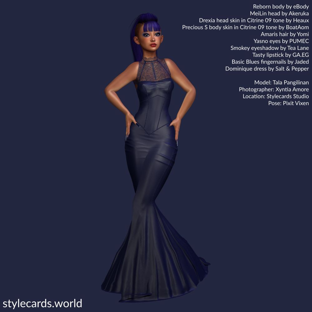 Model Tala Pangilinan wear a dark blue floor-length leather dress adorned with lace at the top. She has a bright blue Mohawk haircut with bangs covering her forehead and she is posed in front of a dark blue backdrop.