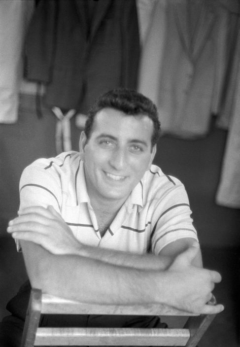 Tony in a striped short-sleeved shirt, arms crossed.