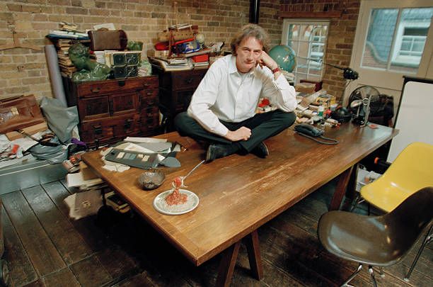 Smith sits cross-legged on top of his desk