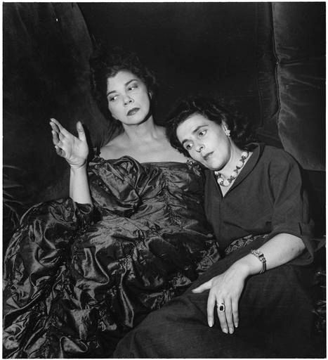The two painters sit together in similar poses.