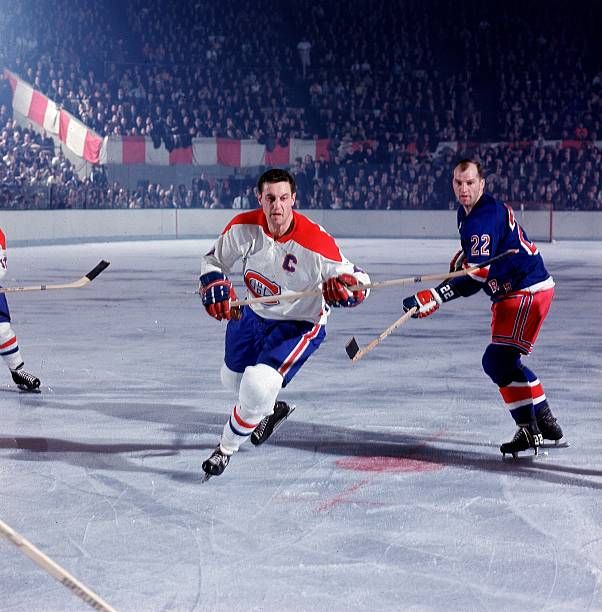 Captain Beliveau skates after the puck, shadowed by Marshall