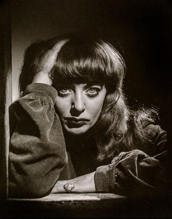 Myers in a corduroy top, hand to her head, looking directly into the camera.