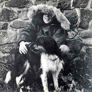 Album back cover
Black & white shot of Simon, his face partially obscured by his parka, with a black & white dog, against a stone wall.