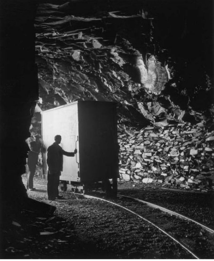 Clark watches as a vault on wheels goes into the cave on rails. 