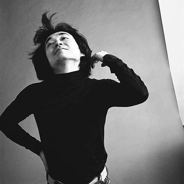 Ozawa in a black turtleneck sweater gestures in a Bernstein fashion.