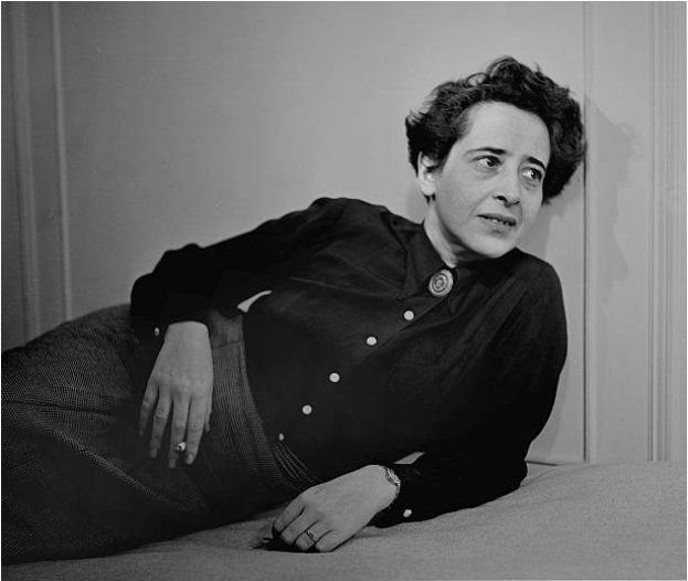 Arendt leans back against the wall, a cigarette in her hand.